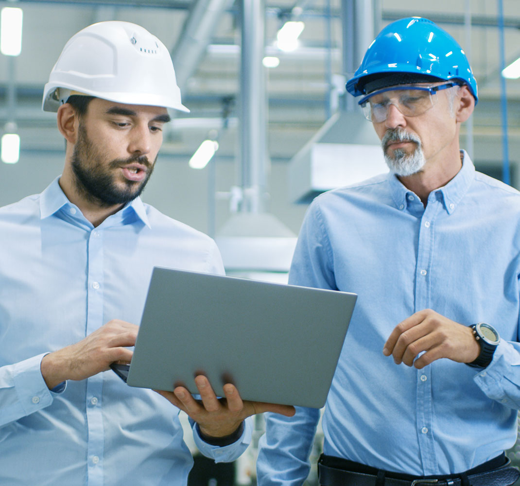 Two manufacturing team leaders looking at laptop