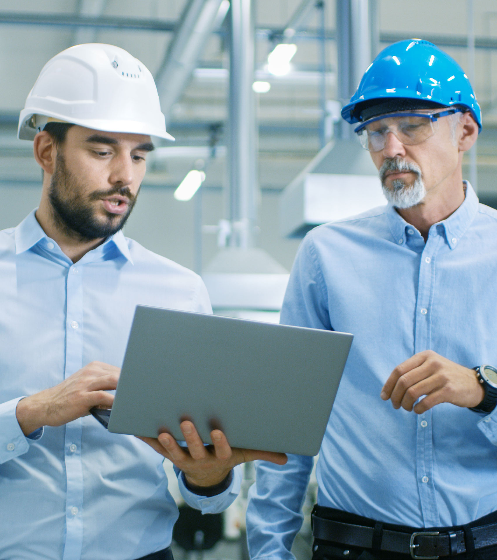 Two manufacturing team leaders looking at laptop