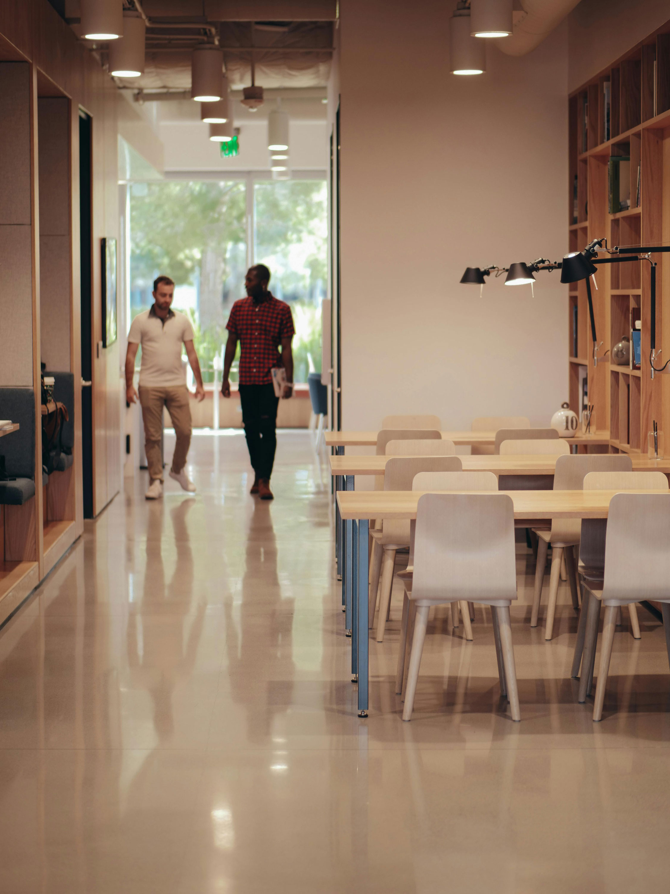 Two employees walking through office